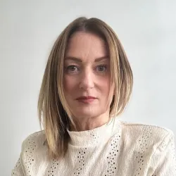 Photograph of a white woman with blonde hair smiling