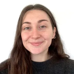 Photograph of a white woman with brown hair smiling