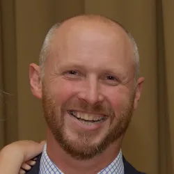 Photograph of a white man smiling