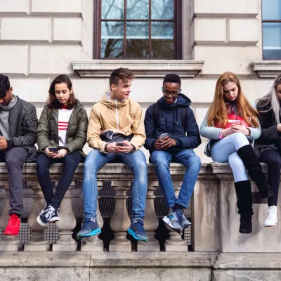 Young people sat on a wall