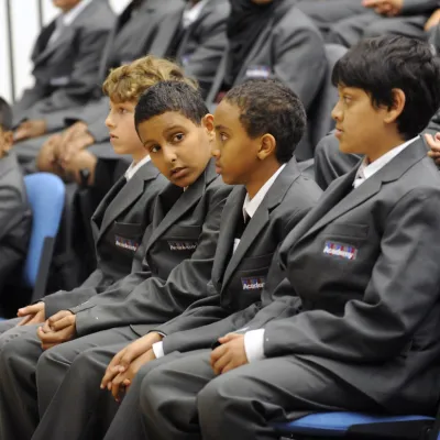 Mixed race school boys sat in an assembly 