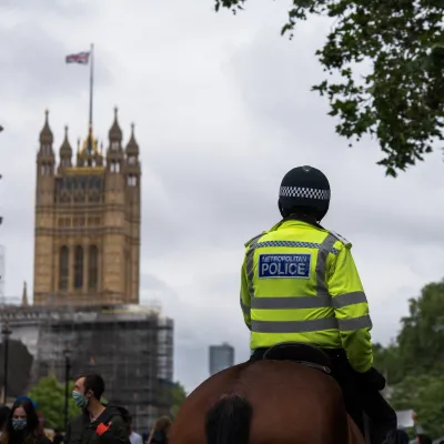 Police on horse in front of houses of parliament 