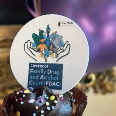 Liverpool FDAC badge in a cake with a balloon behind: photograph from the Liverpool FDAC celebration