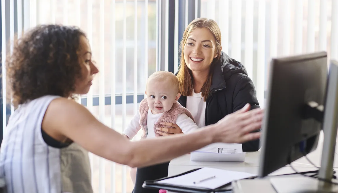 Young woman talking to professional with baby
