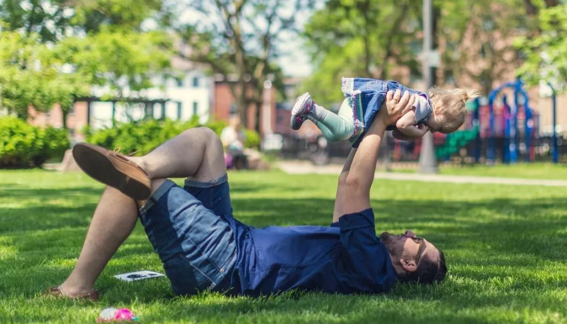 Man holding small girl up in the air