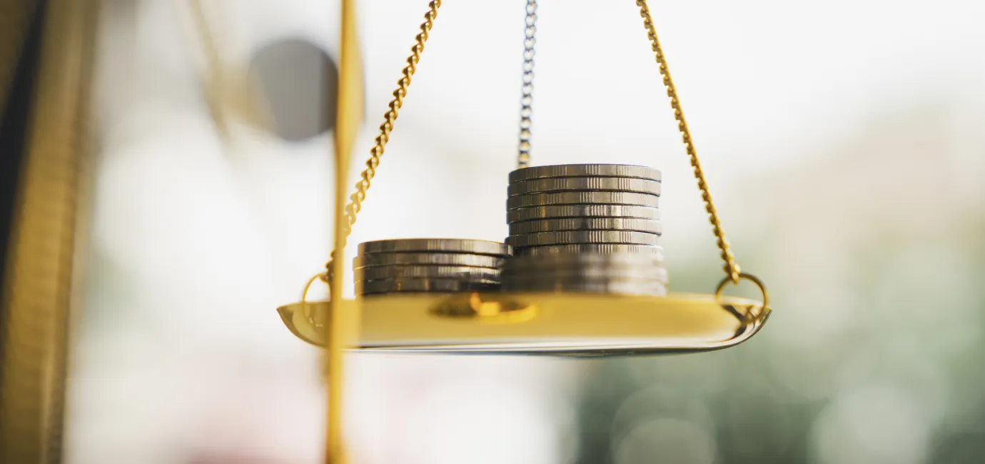 Photograph of coins on the scales of justice